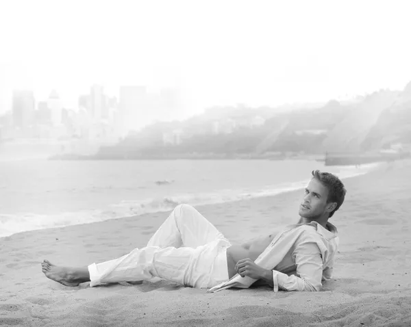Jovem bonito relaxado na praia — Fotografia de Stock