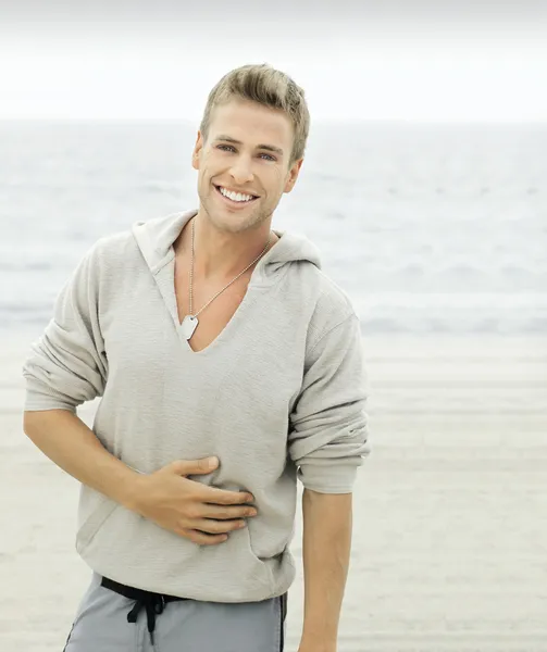 Sahilde bir gülümseme ile genç adam — Stok fotoğraf