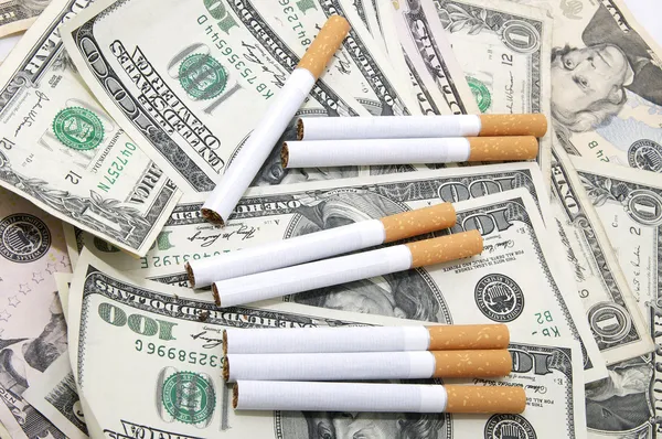 Сигареты и деньги — стоковое фото