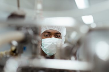 Male researcher checking equipment in biotech industry clipart