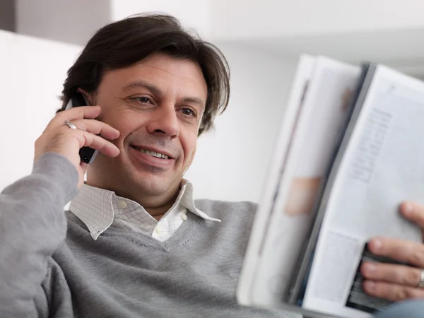 Happy man buying from catalogue with telephone — Stock Photo, Image