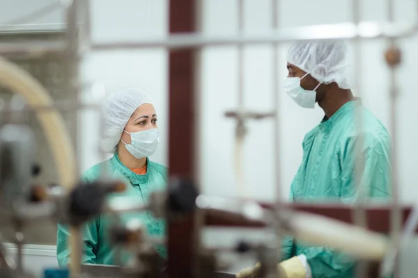 Personal och forskare kontrollera utrustning i biotekniska industrin — Stockfoto