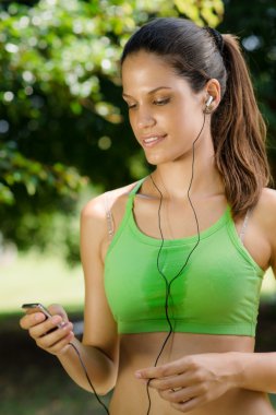 Woman with mp3 player listening to music clipart