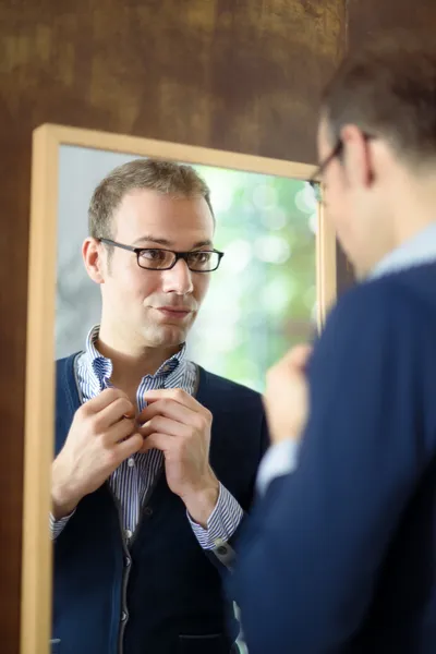 Młody człowiek, ubieranie się i patrząc w lustro — Zdjęcie stockowe