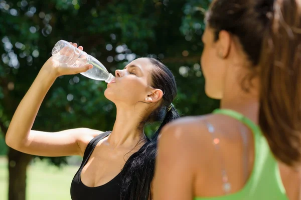 Two young women relaxing after fitness in park — Stock Photo, Image