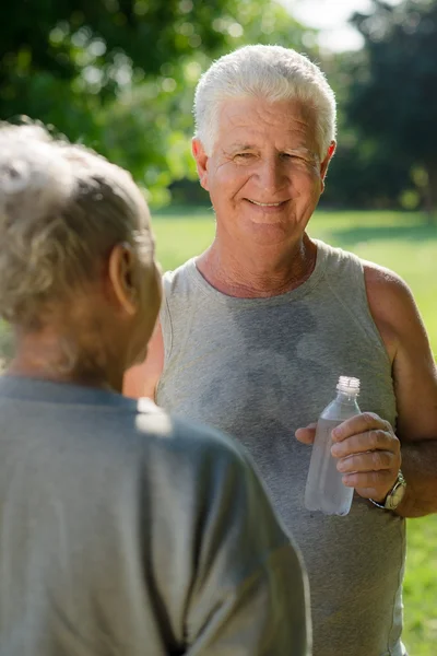 Senioren trinken Wasser nach Fitness im Park — Stockfoto