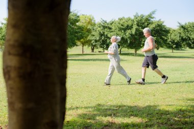 Active senior jogging in city park clipart