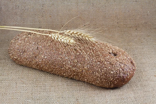 Chleb i pszenicy na grubej tkaniny — Zdjęcie stockowe