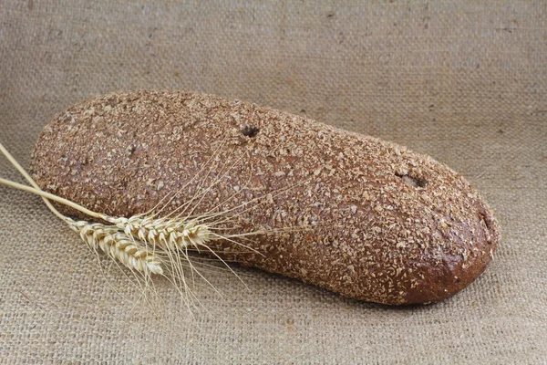 Wholemeal bread with two ears of wheat — Stock Photo, Image