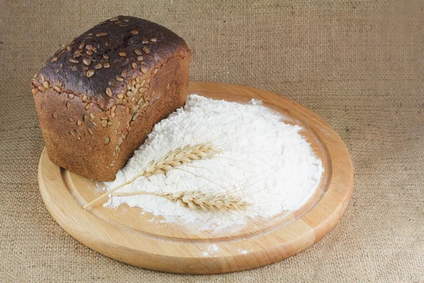 Мука, хлеб, пшеница на кухонной доске — стоковое фото