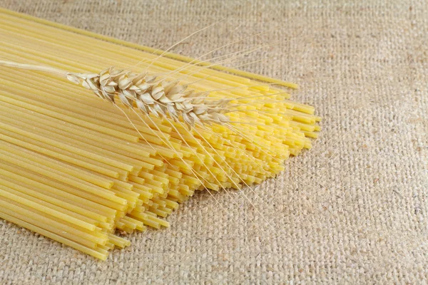 Spaghetti i pszenicy na płótno serweta — Zdjęcie stockowe