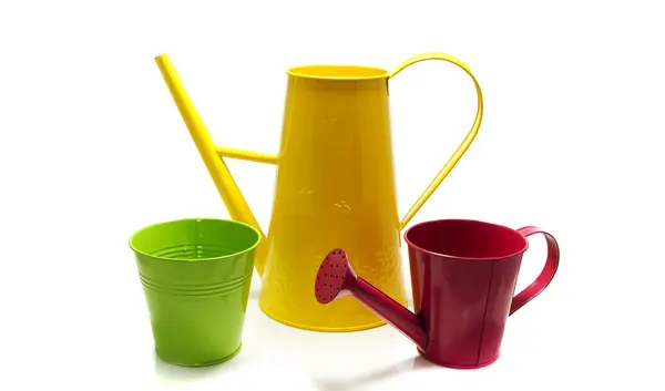 Yellow watering can en green pot — Stock Photo, Image