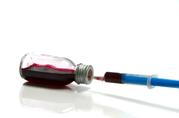 Aiguille médicale en bouteille avec du sang — Photo