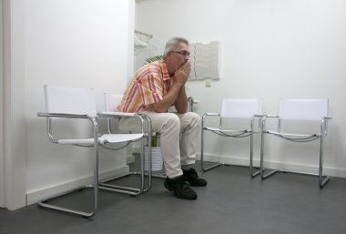 Man sitting and waiting in waitingroom clipart