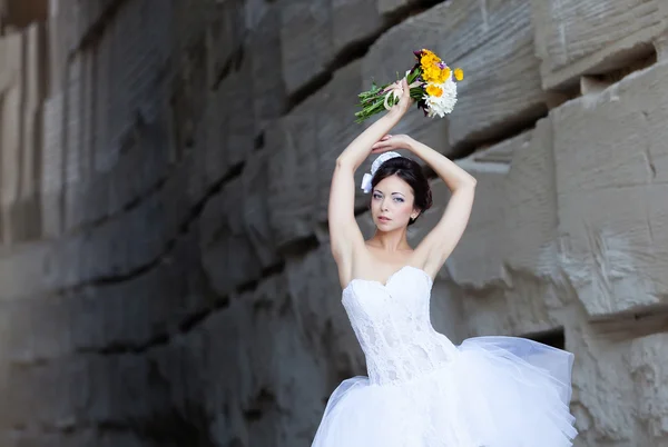 Невеста возле каменной стены — стоковое фото