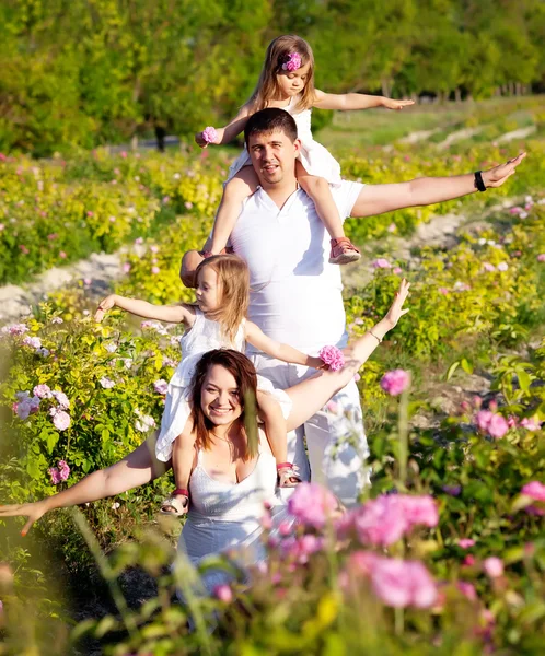 Family in rose flowers — Stock Photo, Image