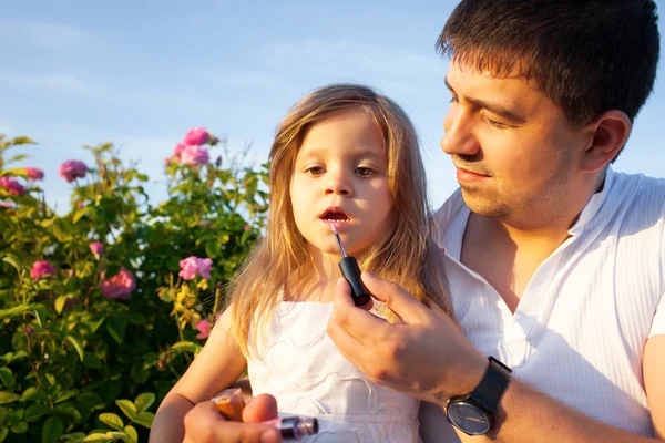 Père avec fille en fleurs roses — Photo