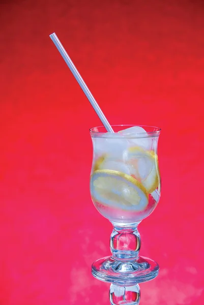 红色背景上的冷鲜柠檬水 — 图库照片