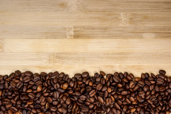 Куча кофейных зерен, образующих простую полосатую рамку — стоковое фото