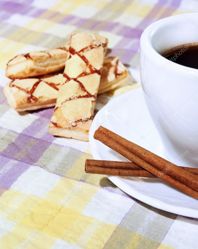 Coffee cup, cinnamon, sweets on the background