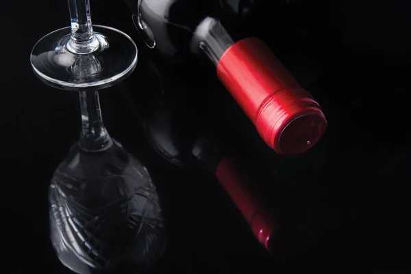 stock image Bottle of wine and a glass on a black background