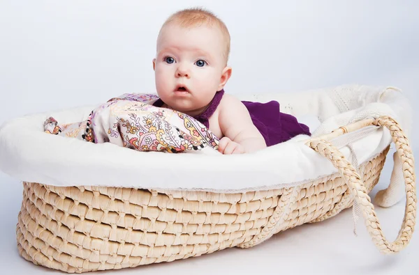 Γλυκό κοριτσάκι, ένα παιδί βρίσκεται σε ένα όμορφο μαξιλάρι σε μια wicke — Φωτογραφία Αρχείου