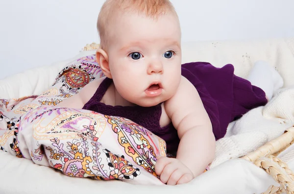 패션 아기 바구니와 시계에 그의 배가에 누워. — 스톡 사진