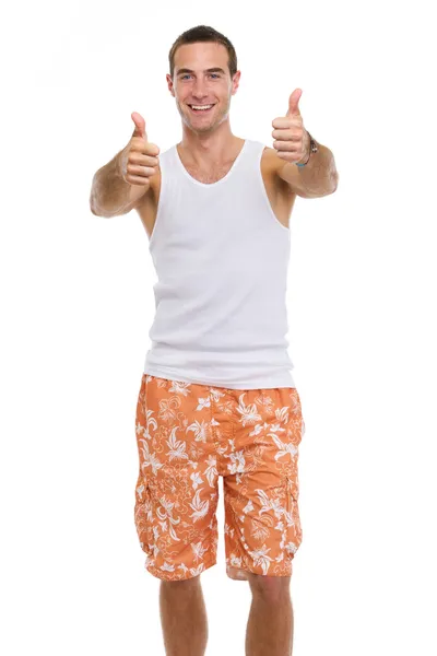 Tatil genç adam şort ve tişört gösteri üzerinde gülümseyen — Stok fotoğraf