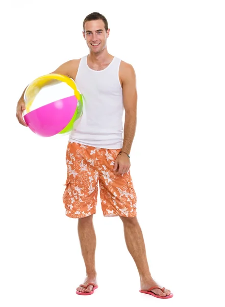 Odpoczynek na wakacje uśmiechający się młody człowiek z piłka plażowa — Zdjęcie stockowe