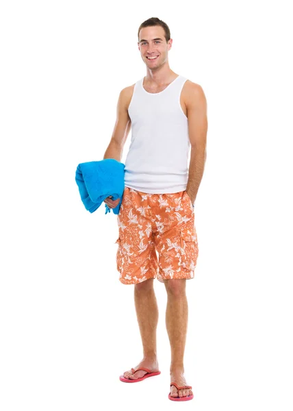Szczęśliwy, spoczywa na wakacje młody facet trzyma niebieski ręcznik — Zdjęcie stockowe