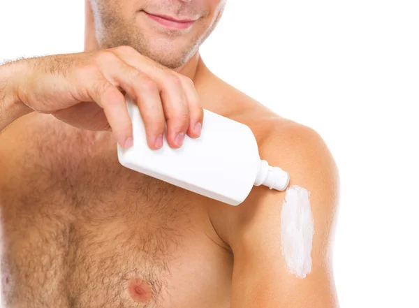 Close-up no homem aplicando creme protetor solar no braço — Fotografia de Stock