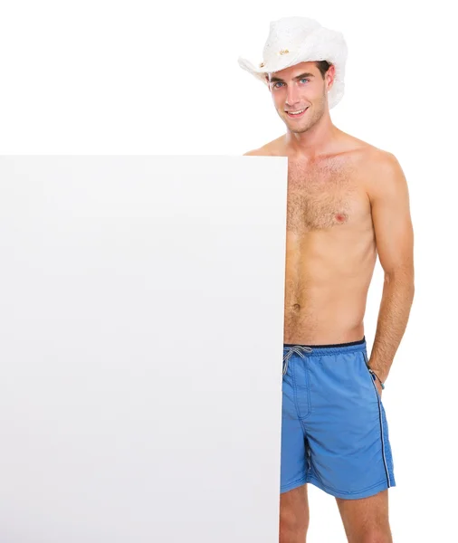 Sonriente tipo con sombrero mostrando cartelera en blanco —  Fotos de Stock