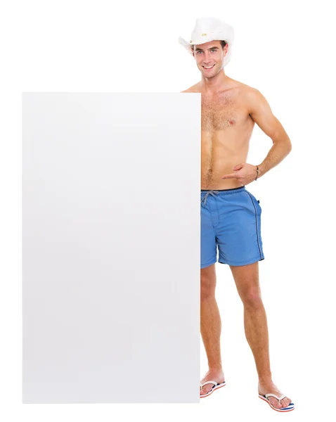 Homem feliz de chapéu apontando em cartaz em branco — Fotografia de Stock