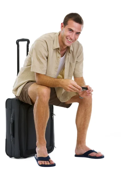 Turista feliz sentado en la bolsa de ruedas y esperando por el avión —  Fotos de Stock