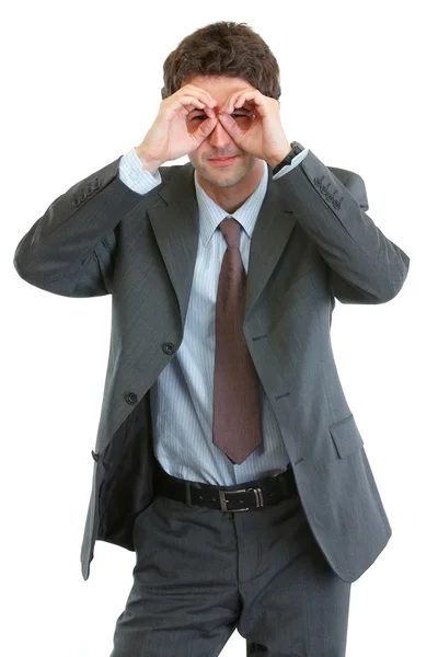 Homem de negócios moderno olhando através de binóculos em forma de mãos — Fotografia de Stock