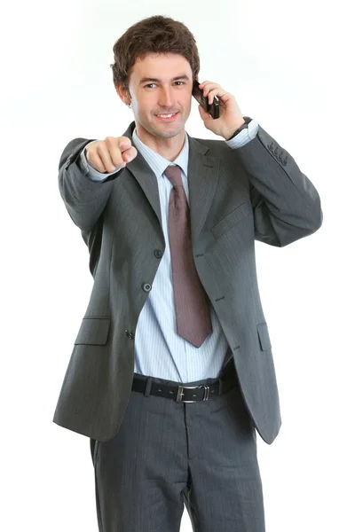 Modern businessman speaking cell phone and pointing on you — Stock Photo, Image