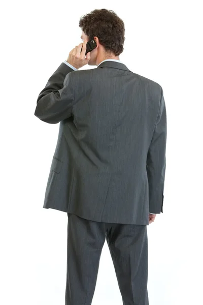 Современный бизнесмен, стоящий спиной к камере и разговаривающий на мобильном p — стоковое фото