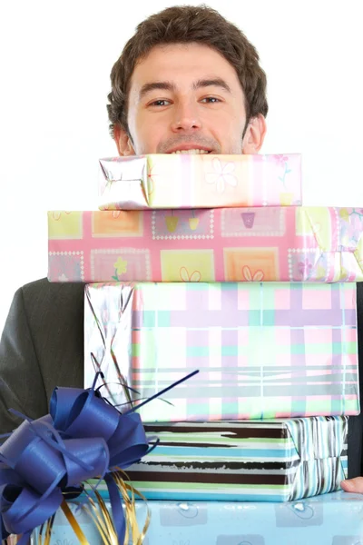 Человек смотрит из стопки подарочных коробок — стоковое фото