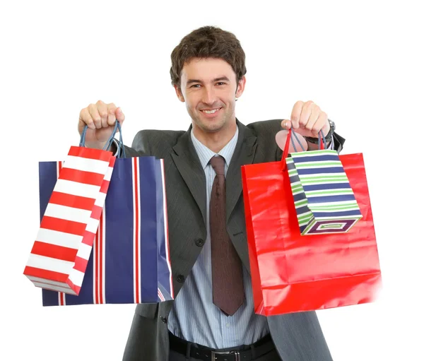Uomo in giacca e cravatta stretching mano con shopping bags — Foto Stock