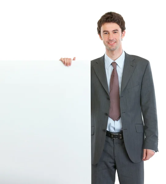 Современный бизнесмен держит пустой рекламный щит — стоковое фото