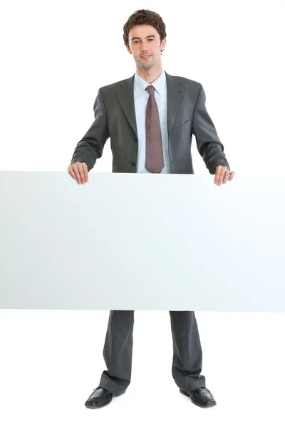 Full length portrait of businessman holding blank billboard — Stock Photo, Image