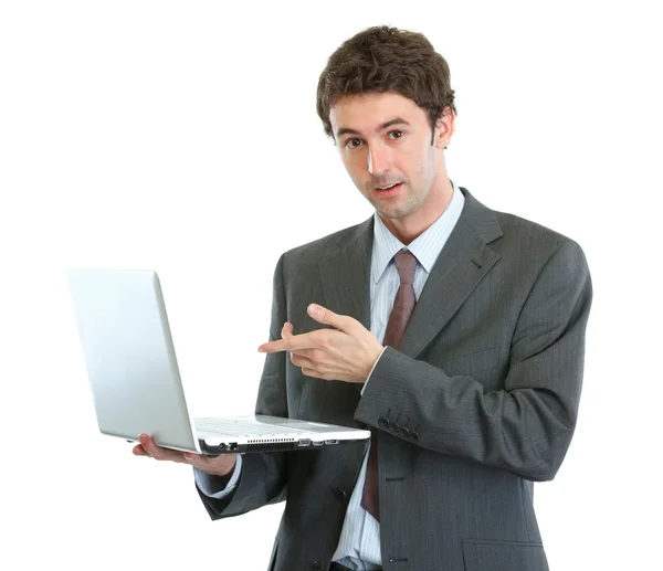Удивленный бизнесмен, указывающий на ноутбук — стоковое фото