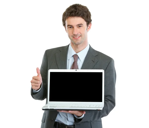Homem de negócios moderno mostrando laptops tela em branco e polegares para cima — Fotografia de Stock
