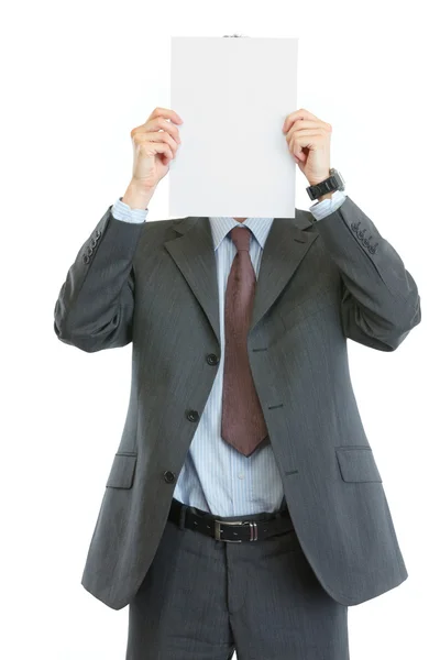 Homem de negócios moderno segurando folha de papel em branco na frente da cara — Fotografia de Stock