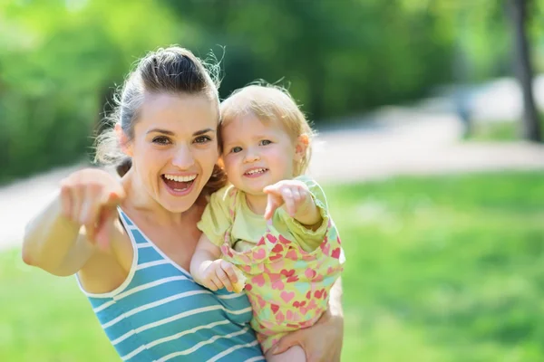 Щаслива мати і дитина вказують в камеру — стокове фото