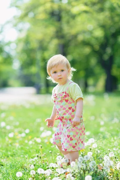 Baby on dandelions field — Stock Photo, Image