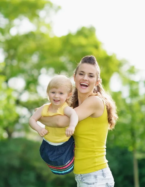 Portret van gelukkige moeder en babymeisje buitenshuis — Stockfoto