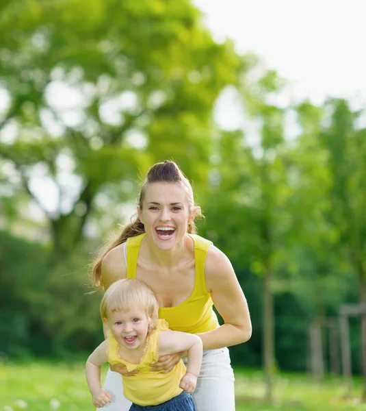 Porträt einer glücklichen Mutter und eines kleinen Mädchens im Park — Stockfoto