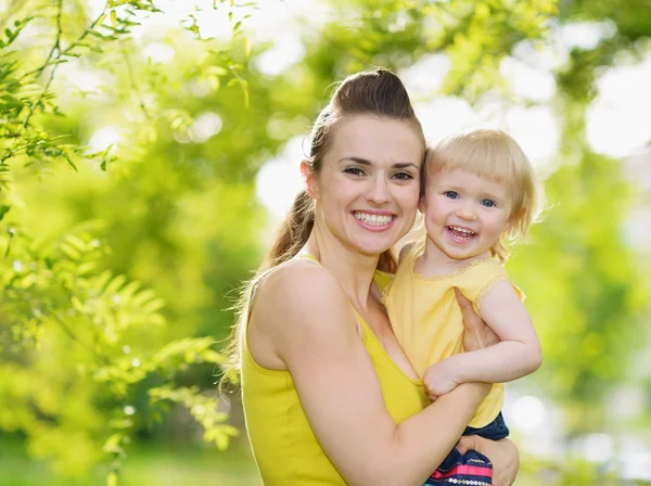 Mosolygó anya és baba lány szabadban portréja — Stock Fotó