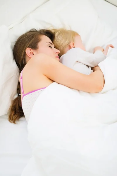 Мать и ребенок спят вместе в постели — стоковое фото